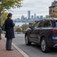Boston rideshare accident claim scene with a passenger beside an unbranded car on a city street