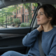 A person pauses beside a parked car as delayed symptoms after a car accident in Boston become noticeable